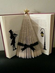 an open book with the pages folded to look like a christmas tree made out of books