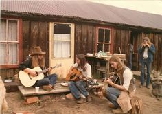 some people are playing guitars outside in the dirt