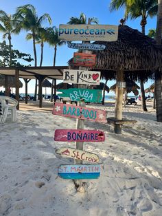 a wooden sign on the beach that says bonaire, be kind of barbeque