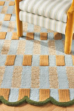 a chair sitting on top of a wooden floor next to a blue and yellow rug