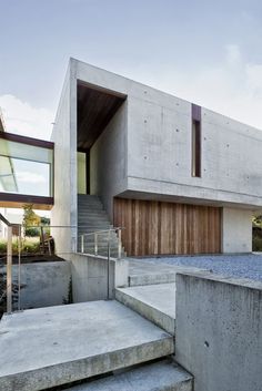 concrete steps lead up to the entrance of this modern house