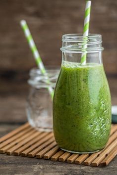 green smoothie in a glass with two straws