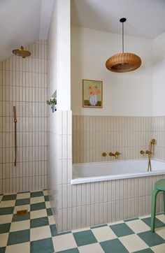 a bathroom with green and white checkered flooring next to a bathtub in the corner