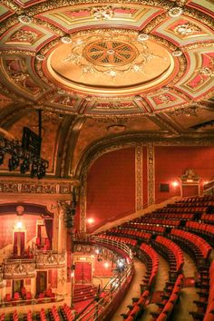 an auditorium with red seats and ornate ceiling