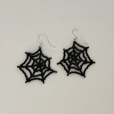 black spider web earrings on white background