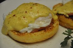 two small pastries on a white plate topped with cheese