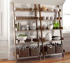 a wooden shelf filled with dishes and cups