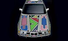 the front end of a white car with colorful designs on it