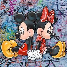 two mickey and minnie mouses standing next to each other in front of graffiti covered walls