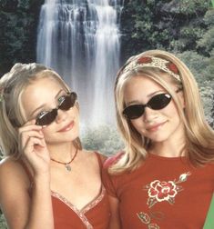 two bikinied girls in front of a waterfall with the caption, island girls
