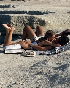 two people are laying on the beach together