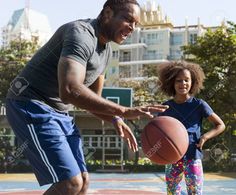 a father and daughter playing basketball in the park stock photo - 957982