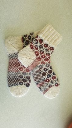 two knitted mittens sitting on top of a table
