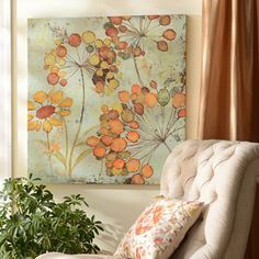 a living room with a large painting on the wall next to a chair and potted plant