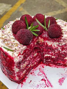 the cake is decorated with berries and white frosting