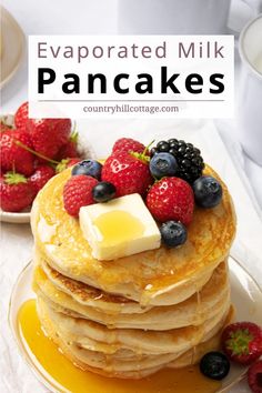 pancakes topped with butter and berries on a plate