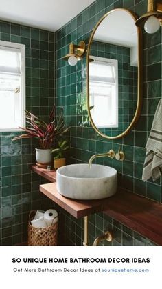 a bathroom with green tiles and a round mirror above the sink, next to a window