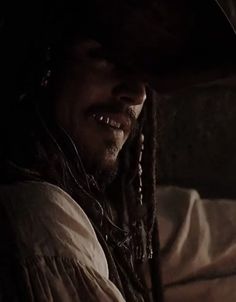 a man with dreadlocks and a hat on sitting in a car at night