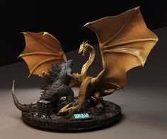 a golden dragon figurine sitting on top of a black base with it's wings spread