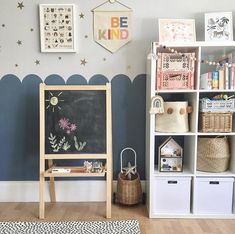 a child's room with a chalkboard and toys on the wall, bookshelves