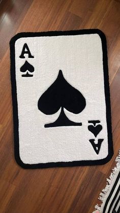 a white rug with black and white playing card symbols on the front, along with a pair of spades