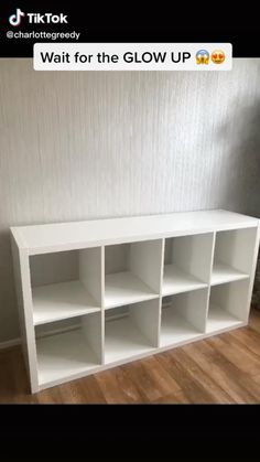 a white shelf with six cubbys in it on the floor next to a wall