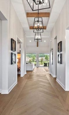 a large open floor plan with wood floors and chandelier hanging from the ceiling