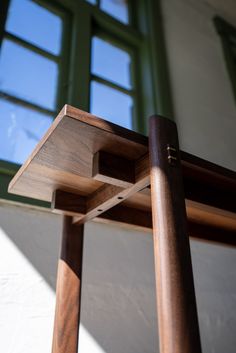 a close up of a wooden table with windows in the background