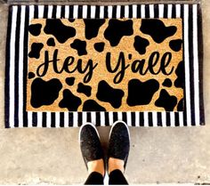 a person standing in front of a door mat that says hey yaee