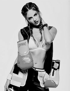 a black and white photo of a woman wearing boxing gloves