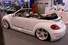 a white convertible car parked inside of a showroom