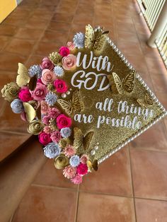 a graduation cap with flowers and butterflies on it that says, with god all things are possible