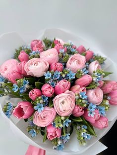 a bouquet of pink roses and blue flowers