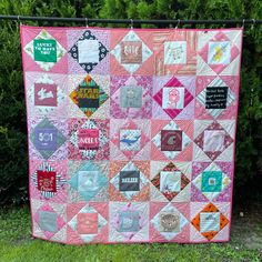 a pink and white quilt hanging from a fence