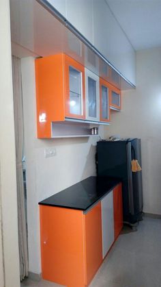 an orange and white kitchen with black counter tops