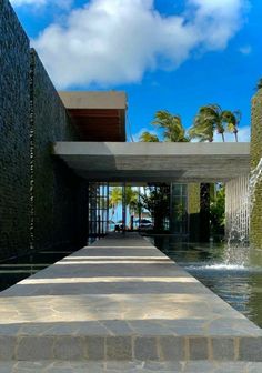 the walkway is lined with water and stone steps that lead up to an entry way