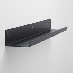 a black shelf with two brass rivets on it