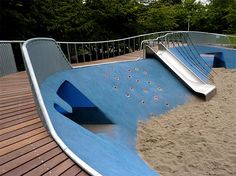 a skateboard ramp in the middle of a wooden decked area with trees in the background