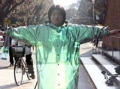 a man in a green raincoat standing next to a bike