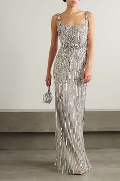 a woman wearing a silver dress with sequins