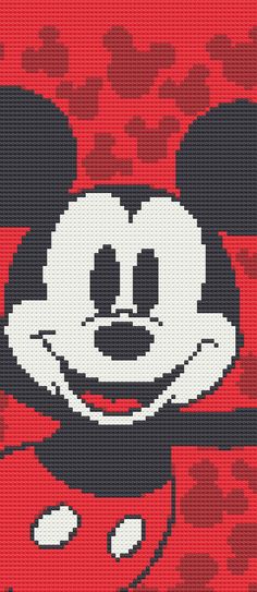 a cross stitch mickey mouse with red and black dots in the background, it looks like he is smiling