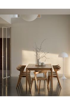 a dining room table with chairs and a vase on it