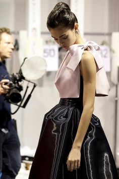 a woman standing in front of a camera