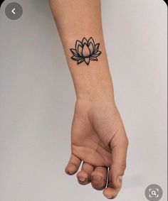 a person's arm with a tattoo on it that has a lotus flower on the wrist