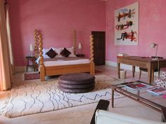 a bedroom with pink walls and furniture in it