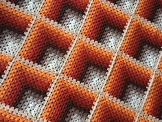 an orange and white crocheted blanket with squares