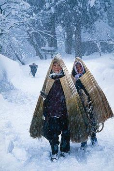 two people walking in the snow carrying baskets