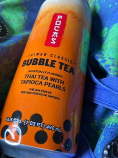 a can of bubble tea sitting on top of a blanket