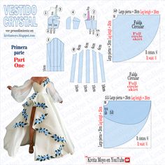 a paper doll is wearing a white dress with blue flowers on the skirt and cape