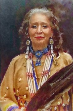 a woman in native clothing holding a large piece of wood